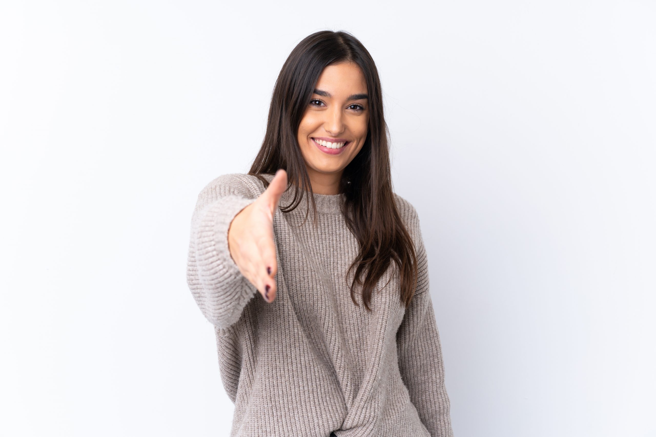 Young brunette woman over isolated white background shaking hands for closing a good deal